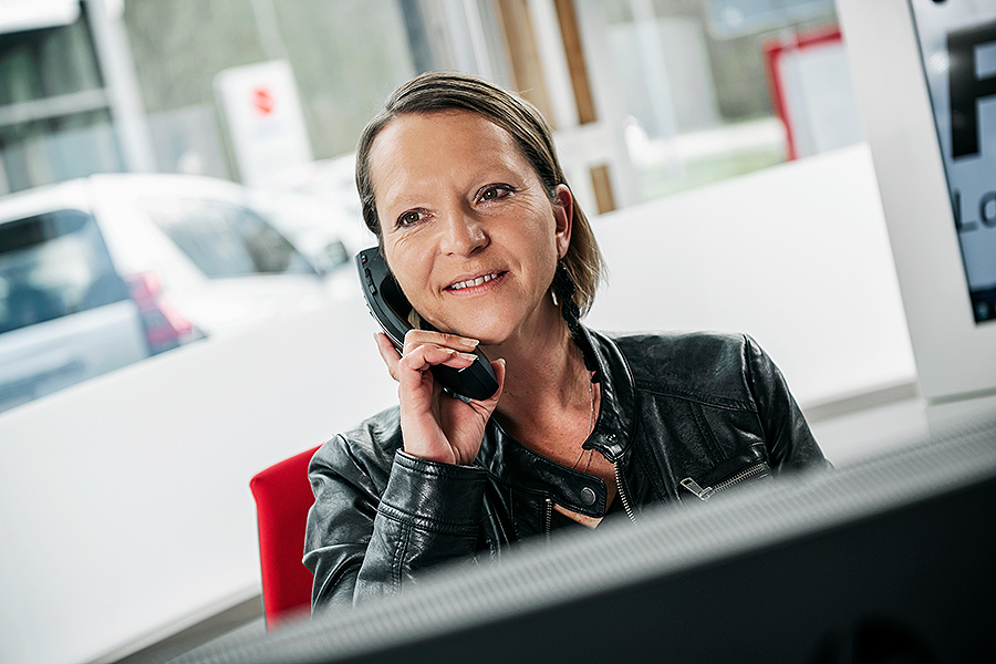 Eine Person in einer Lederjacke sitzt drinnen am Fenster und benutzt ein Smartphone. Sie repräsentiert den kompetenten Kundendienst der Frey Auto AG beim Verkauf von Toyota-, Lexus- und Suzuki-Autos. Das Bild spiegelt unser Engagement für umfassende Autodienstleistungen wider, darunter MFK-Inspektionen, Reifenservice, Routinewartungen, Karosseriereparaturen und professionelle Autowäschen.