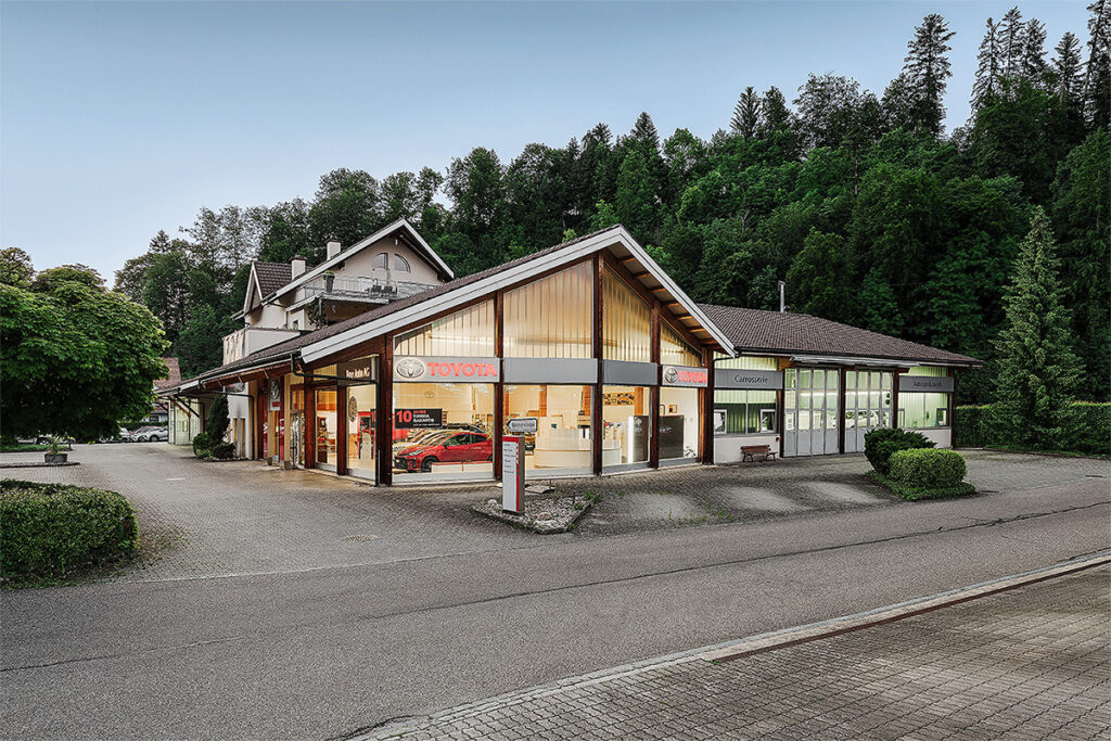 Das Autohaus Frey Auto AG präsentiert durch große Schaufenster eine beeindruckende Sammlung von Toyota-, Lexus- und Suzuki-Fahrzeugen. Inmitten üppiger Grünflächen und klarer Himmel gelegen, bietet dieses Automobilzentrum umfassende Dienstleistungen, darunter MFK-Inspektion, Reifenservice, Routinewartung, Karosseriereparaturen und professionelle Autowaschanlagen. Entdecken Sie das vielfältige Angebot für den Verkauf von Neu- und Gebrauchtwagen in einer Umgebung, die Natur nahtlos mit modernster Automobilinnovation verbindet.