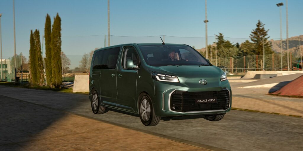 Ein leuchtend grüner Toyota Proace Verso Van fährt auf einer Panoramastraße vor einer Kulisse aus üppigem Grün und Parkausstattung unter einem klaren blauen Himmel. Frey Auto AG bietet fachmännische MFK-Inspektion, zuverlässigen Reifenservice, umfassenden Autoservice und Wartung für alle Toyota-Modelle. Entdecken Sie hochwertige Karosserielösungen, genießen Sie effiziente Autowaschdienste oder entdecken Sie Neu- und Gebrauchtwagenverkäufe in unserem Autohaus. Erleben Sie Spitzenqualität bei Top-Automobilmarken wie Toyota, Lexus und Suzuki mit Frey Auto AG.