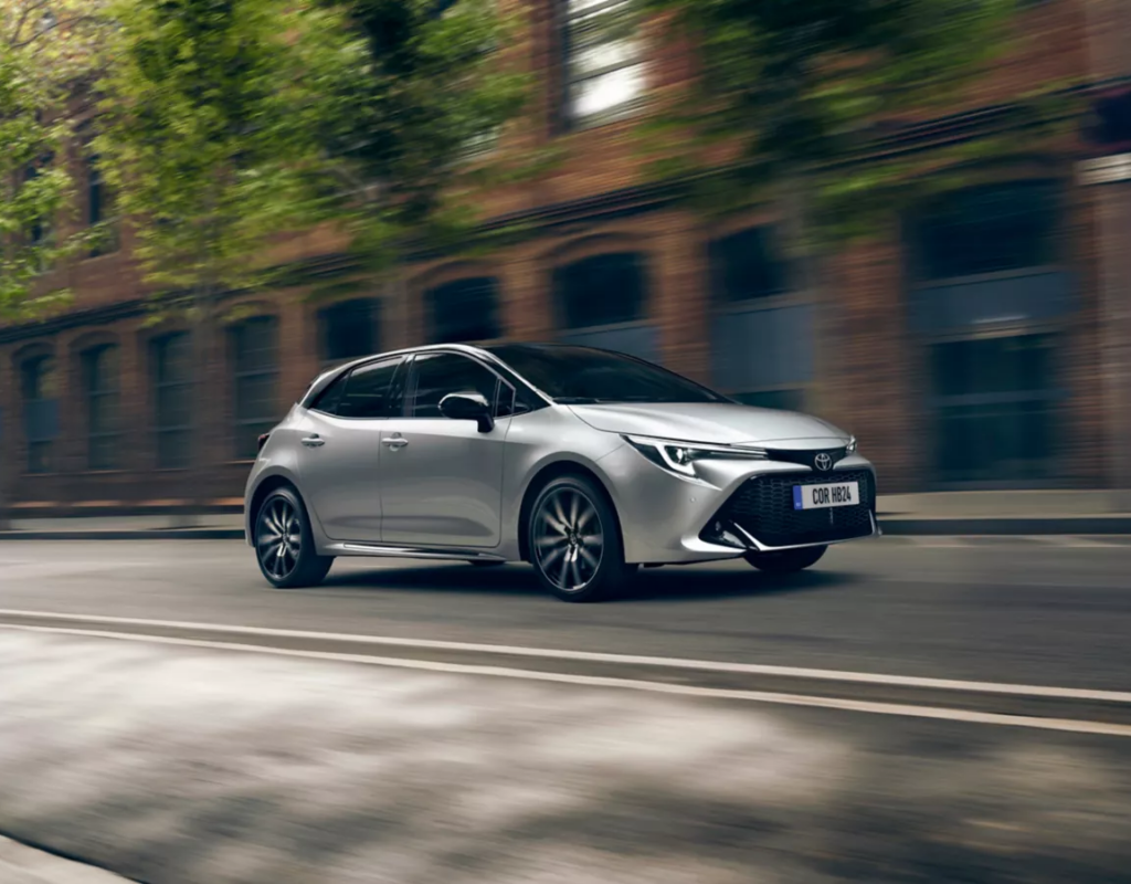 Eine silberne Toyota-Limousine navigiert durch eine belebte Stadtstraße, mit verschwommener urbaner Architektur im Hintergrund. Frey Auto AG bietet fachmännische MFK-Inspektionen, umfassende Reifenservices und sorgfältige Autowartung für Toyota-, Lexus- und Suzuki-Fahrzeuge. Entdecken Sie unseren Premium-Autoverkaufsbestand mit diesen Top-Marken und profitieren Sie von unserer hochmodernen Karosserie und unseren makellosen Autowaschdiensten, um Ihr Fahrzeug in Topzustand zu halten.