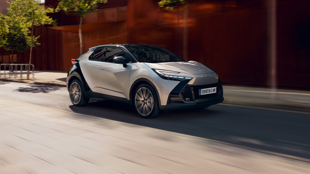 Ein kompakter SUV in Metallic-Grau mit elegantem Design befährt eine Stadtstraße, die von modernen Gebäuden und verschwommenem Grün gesäumt ist. Frey Auto AG bietet umfassende Autoservices für Fahrzeuge der Marken Toyota, Lexus und Suzuki, darunter MFK-Inspektion, fachmännischer Reifenservice, routinemäßige Wartungskontrollen, sorgfältige Karosseriereparaturen, wettbewerbsfähige Autoverkaufsoptionen für Neu- und Gebrauchtmodelle sowie Premium-Autowaschlösungen.