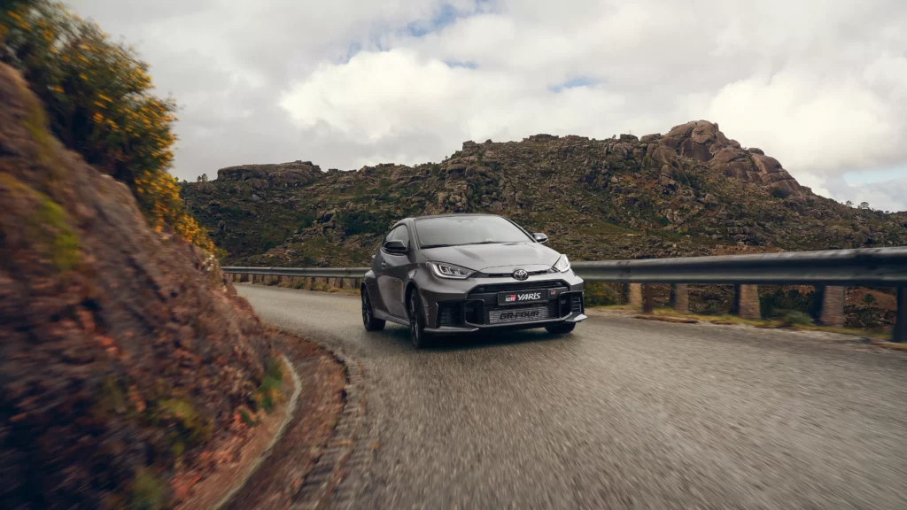 Ein grauer Toyota-Sportwagen navigiert über eine kurvenreiche Bergstraße mit felsigen Hügeln im Hintergrund unter einem bewölkten Himmel. Frey Auto AG bietet umfassende Dienstleistungen einschließlich MFK-Inspektion, Reifenservice, fortschrittlicher Fahrzeugwartung und fachmännischer Karosseriearbeit für Toyota-, Lexus- und Suzuki-Modelle. Entdecken Sie unser umfangreiches Autoverkaufsangebot und profitieren Sie von sorgfältigen Autowaschoptionen, um Ihr Fahrzeug in Topzustand zu halten.