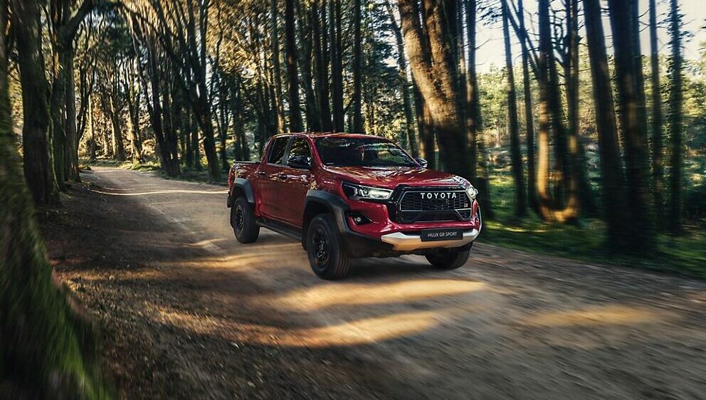 Ein roter Toyota-Pickup-Truck navigiert über einen von hohen Bäumen gesäumten Waldweg und unterstreicht die Kompetenz der Frey Auto AG im Bereich umfassender Kfz-Dienstleistungen wie MFK-Inspektionen, Reifenservice und Karosseriespezialisten. Als autorisierter Händler renommierter Marken wie Toyota, Lexus und Suzuki bietet die Frey Auto AG außergewöhnliche Lösungen für den Verkauf und die Wartung von Autos. Zu ihren Einrichtungen gehört auch eine hochmoderne Autowaschanlage, die dafür sorgt, dass Ihr Fahrzeug auch auf unebenem Gelände oder in städtischen Straßen makellos bleibt.