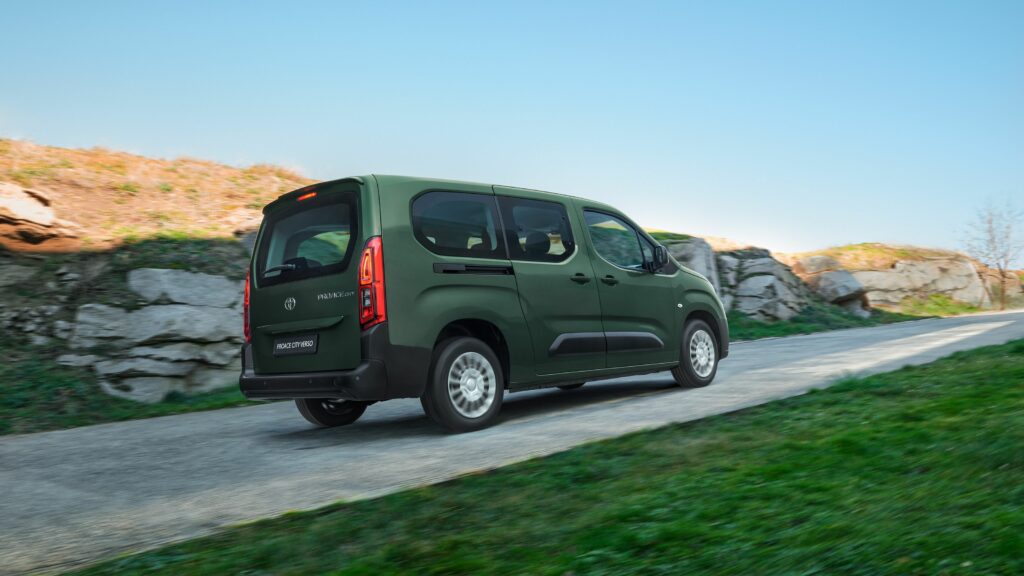 Ein grüner Toyota-Van fährt an einem klaren Tag auf einer Landstraße mit Grasrändern und felsiger Landschaft und stellt die Kompetenz der Frey Auto AG in Sachen MFK-Inspektionen, umfassendem Reifenservice und fachmännischer Karosseriearbeit unter Beweis. Das Unternehmen ist auf den Verkauf von Neu- und Gebrauchtwagen spezialisiert und bietet Premiummarken wie Toyota, Lexus und Suzuki an. Erleben Sie die sorgfältige Sorgfalt ihrer professionellen Autowaschdienste und genießen Sie gleichzeitig erstklassige Autowartung bei der Frey Auto AG.